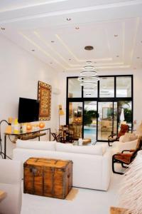 a living room with a white couch and a chandelier at Villa el Kasbah in Midoun