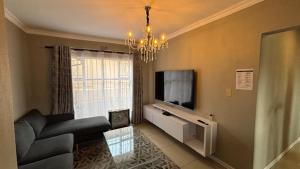 a living room with a couch and a television at Selina Guesthouse in Kempton Park