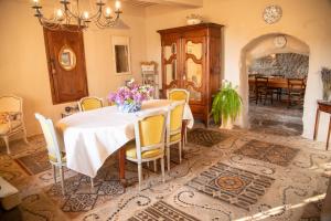 a dining room with a table with flowers on it at Le Vieux Castel in Roumoules