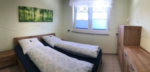 two beds sitting in a room with a window at Kompassrose in Prerow