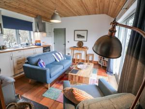 a living room with a blue couch and a table at Bosca Neadu in Dingle