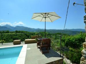 - une terrasse avec une table et un parasol à côté de la piscine dans l'établissement Belvilla by OYO Casa Mazzola, à Fivizzano