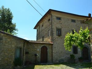 une vieille maison en pierre avec un arbre en face de celle-ci dans l'établissement Belvilla by OYO Casa Mazzola, à Fivizzano
