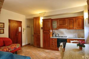 a kitchen with wooden cabinets and a kitchen table at La Torre Nomipesciolini in San Gimignano