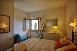 a bedroom with a bed and a dresser and a window at La Torre Nomipesciolini in San Gimignano +20 photos