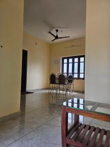 a dining room with chairs and a ceiling fan at Rajadhani Apartment in Karunāgapalli +8 photos