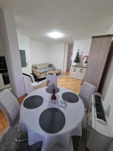 a living room with a white table and white chairs at Plavi Safir stan in Bijeljina