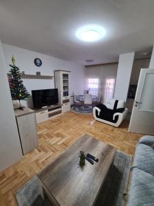 a living room with a christmas tree and a table at Plavi Safir stan in Bijeljina