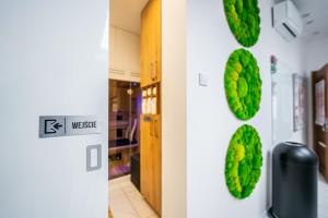 a hallway with green leaves on the wall at BioKompas SPA Apartment in Wrocław