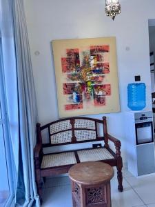 a bench in a room with a painting on the wall at Diani Exquisite 3BR in Ukunda