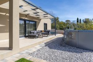 a patio of a house with a table and chairs at Casa Mia in Rebići