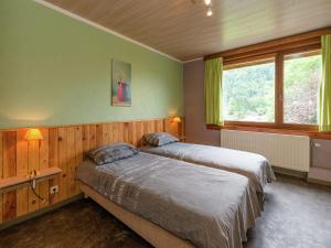 2 Betten in einem Schlafzimmer mit grünen Wänden und einem Fenster in der Unterkunft Appealing holiday home in Malm dy with indoor pool in Malmedy