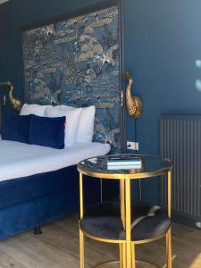a bedroom with a bed and a table with a stool at The Rock in Zandvoort
