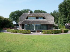 a large house with a thatched roof at Mansion in Nijensleek with Sauna & Garden in Nijensleek