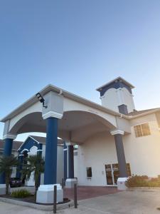 a large white building with blue columns at Crystal Inn - Garth Rd in Baytown