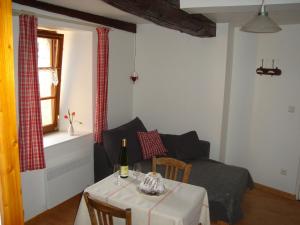 a living room with a table and a couch at A studio apartment on the first floor of a wine grower s house in Riquewihr