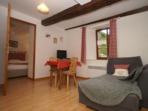 a living room with a couch and a table at A studio apartment on the first floor of a wine grower s house in Riquewihr