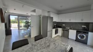 a kitchen with a table and a dining room at Protaras Heights- Hana in Paralimni