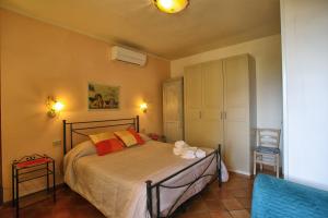 a bedroom with a bed and a blue chair at La Torre Nomipesciolini in San Gimignano