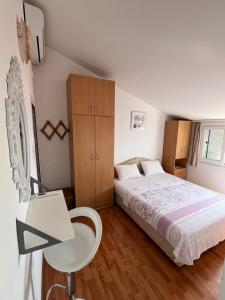 a bedroom with a bed and a desk and a table at Apartments Teodora Obala in Petrovac na Moru