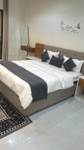 a large bed with white sheets and blue pillows at كيان ( KAYAN) in Sūr ash Shiyādī +26 photos