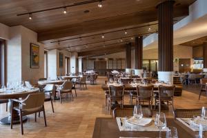 a restaurant with tables and chairs in a room at Les Bungalows in Torbalı