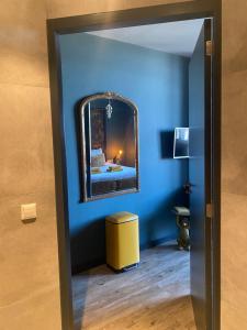 a blue room with a mirror and a yellow stool at The Rock in Zandvoort