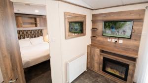 a bedroom with a bed and a fireplace at 6. Supreme OD 3 Caravan with Decking in Ringwood