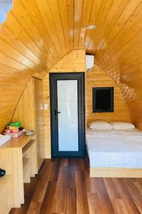 a small bedroom with a bed and a tv at Khu du lịch nghỉ dưỡng Thạch Lâm Retreat in Thanh Hối