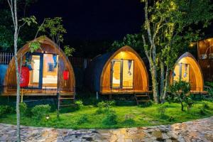 a group of three yurt homes in a yard at night at Khu du lịch nghỉ dưỡng Thạch Lâm Retreat in Thanh Hối