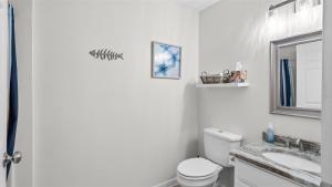 a bathroom with a toilet and a sink and a mirror at 209 E Andrews Ave, Unit A in Wildwood +28 photos