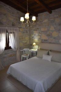 a bedroom with a large bed in a stone wall at Villa Arvi in Arvi