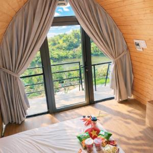 a table with food on a bed in front of a window at Khu du lịch nghỉ dưỡng Thạch Lâm Retreat in Thanh Hối