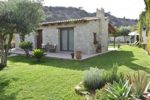 a stone house in a garden with a lawn at Villa Arvi in Arvi