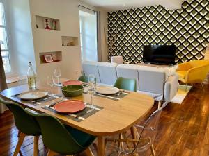 a dining room with a wooden table and chairs at AppartCosy 19 in Vitré
