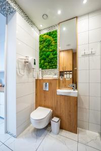 a bathroom with a toilet and a painting of fruits at BioKompas SPA Apartment in Wrocław +36 photos