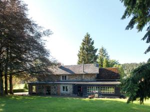 una casa de piedra con un patio y árboles en Holiday Home in Lavacherie with Terrace, en Sainte-Ode