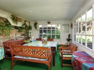 ein Esszimmer mit einem Tisch, Stühlen und Fenstern in der Unterkunft Holiday Home in Lavacherie with Terrace in Sainte-Ode
