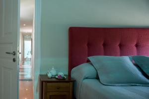 a bed with a red headboard in a bedroom at Santorini Gem in Órmos Athiniós