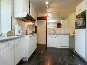 a kitchen with white cabinets and a black floor at Holiday Home in Lavacherie with Terrace in Sainte-Ode