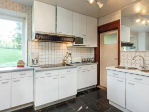 cocina con armarios blancos, fregadero y ventana en Holiday Home in Lavacherie with Terrace, en Sainte-Ode