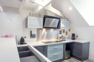 a kitchen with stainless steel cabinets and a sink at AppartCosy 04 in Vitré