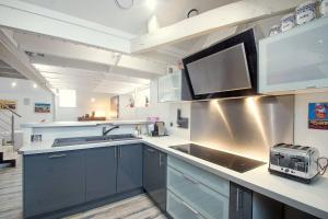 a kitchen with a sink and a microwave at AppartCosy 04 in Vitré +18 photos