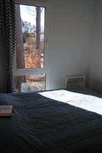a bedroom with a bed and a large window at Lillstugorna in Ljungskile