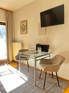 a room with a table and chairs and a television at Weingut Sauer-Kettermann in Enkirch