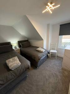 a bedroom with two beds and a ceiling fan at Home in Macduff in Macduff +2 photos