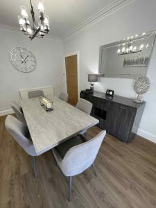 a dining room with a table and chairs and a clock at Home in Macduff in Macduff