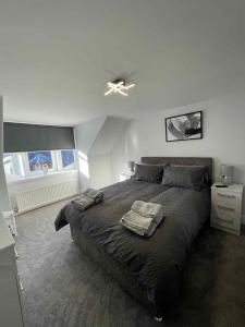 a bedroom with a bed with two towels on it at Home in Macduff in Macduff