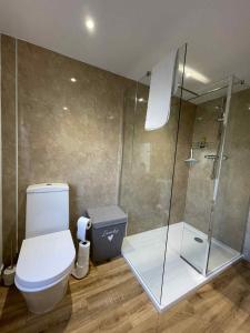 a bathroom with a toilet and a glass shower at Home in Macduff in Macduff