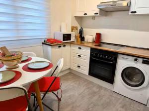 a kitchen with a table and a washing machine at Las Alas in Avilés